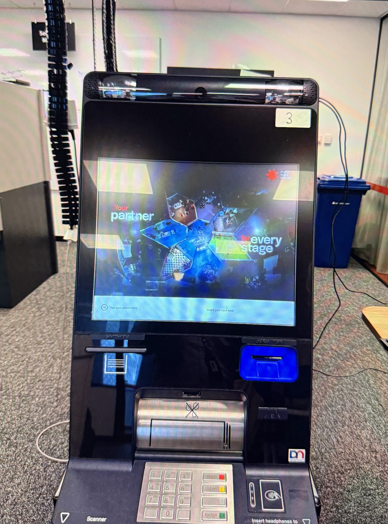 Close-up of ATM hardware with screen glare from overhead lighting